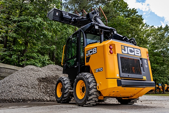 Rear three-quarter view of JCB 270 skid steer loader at a construction materials site