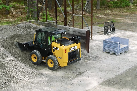 JCB 270 skid steer loader loading bulk material inside a storage yard