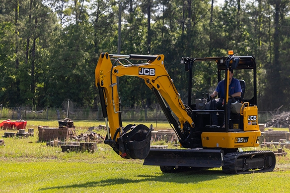 JCB 35Z-1 mini excavator digging and grading ground during outdoor landscaping work