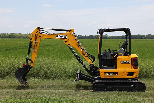 Side profile of JCB 35Z-1 mini excavator with digging bucket in an open field