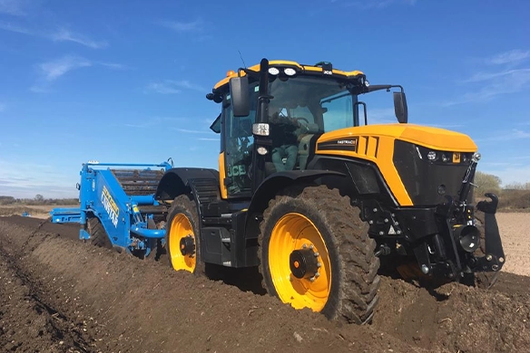 JCB 4000 Series tractor operating with a blue tillage implement, demonstrating advanced traction and precision soil cultivation