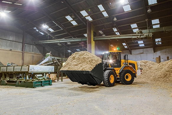 JCB 427 Agri wheel loader loading loose material inside an agricultural storage shed