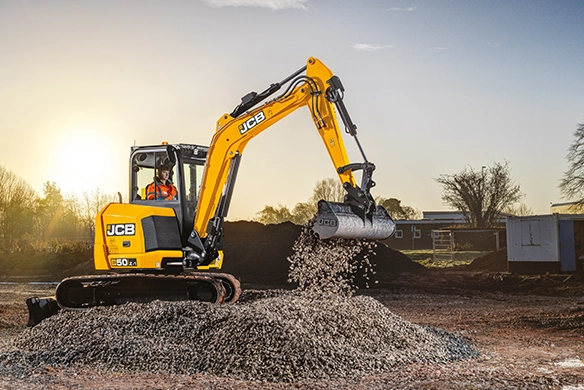JCB 50Z-1 mini excavator loading gravel during groundworks on a construction site