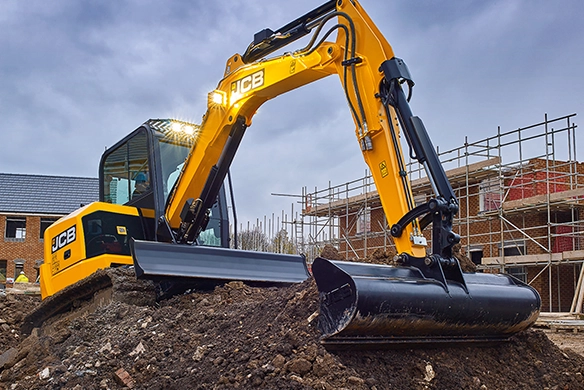 JCB 50Z-1 mini excavator excavating soil on a residential construction site