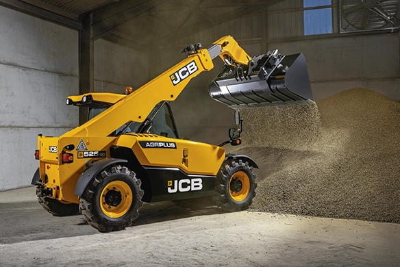 JCB 525-60 telescopic handler loading loose material inside an agricultural shed