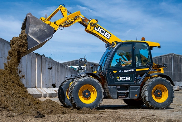 JCB 538-60 Agri telehandler loading silage against a concrete clamp wall