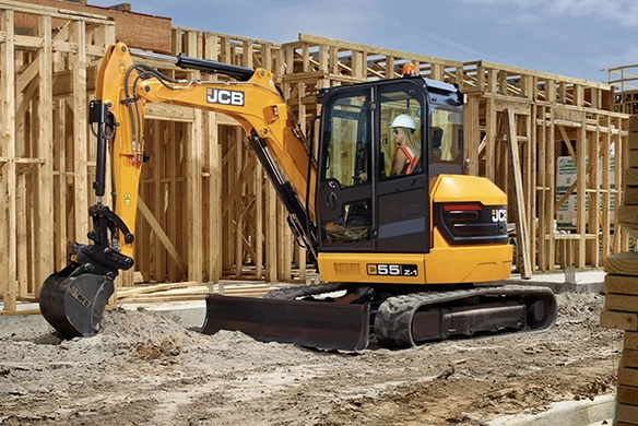 JCB 55Z-1 mini excavator working on a residential construction site with timber framing