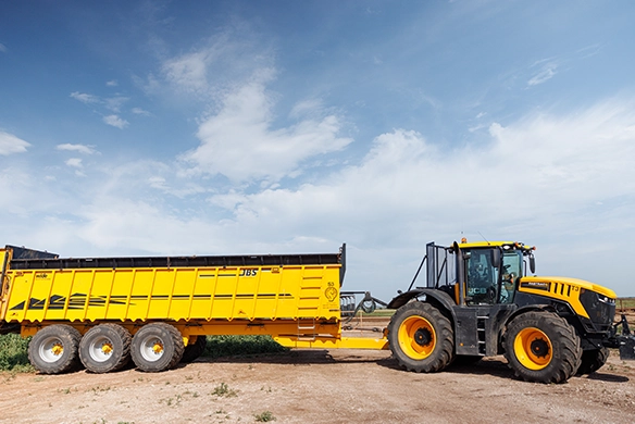 JCB 8000 Series tractor pulling a large yellow agricultural trailer