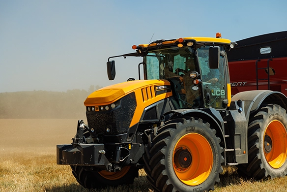 JCB 8000 Series tractor operating in a dusty field during harvest