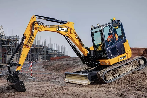 JCB 85Z-1 mini excavator working on uneven ground at a large construction project