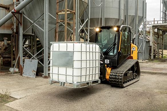 JCB 270T compact track loader operating in an industrial facility with bulk containers