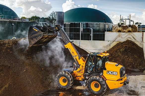 JCB TM420 telescopic wheel loader handling bulk organic material at a facility