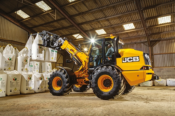 JCB TM420 telescopic wheel loader lifting bulk bags inside an agricultural storage building