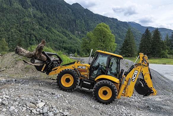 JCB 4CX PRO backhoe loader handling timber with front loader attachment on a rocky off-road site