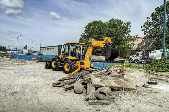 JCB 4CX PRO backhoe loader handling demolition material on an urban construction site