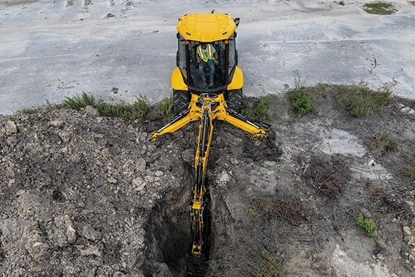 Overhead view of JCB 4CX PRO backhoe loader excavating a trench
