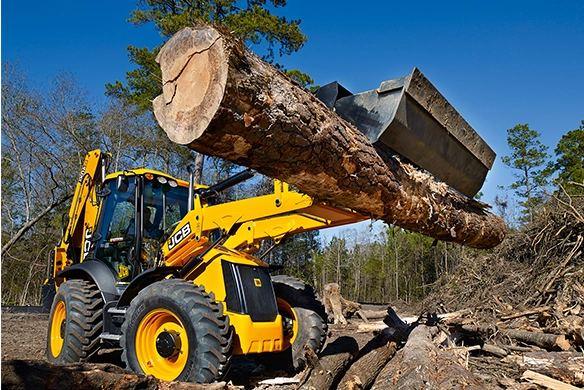 JCB 4CX PRO backhoe loader moving large timber during land clearing operations