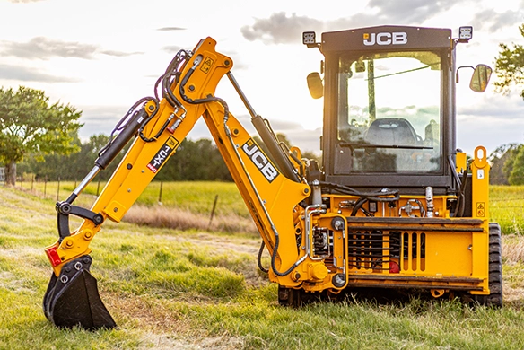 Rear view of JCB 1CXT compact track backhoe loader with excavator attachment deployed