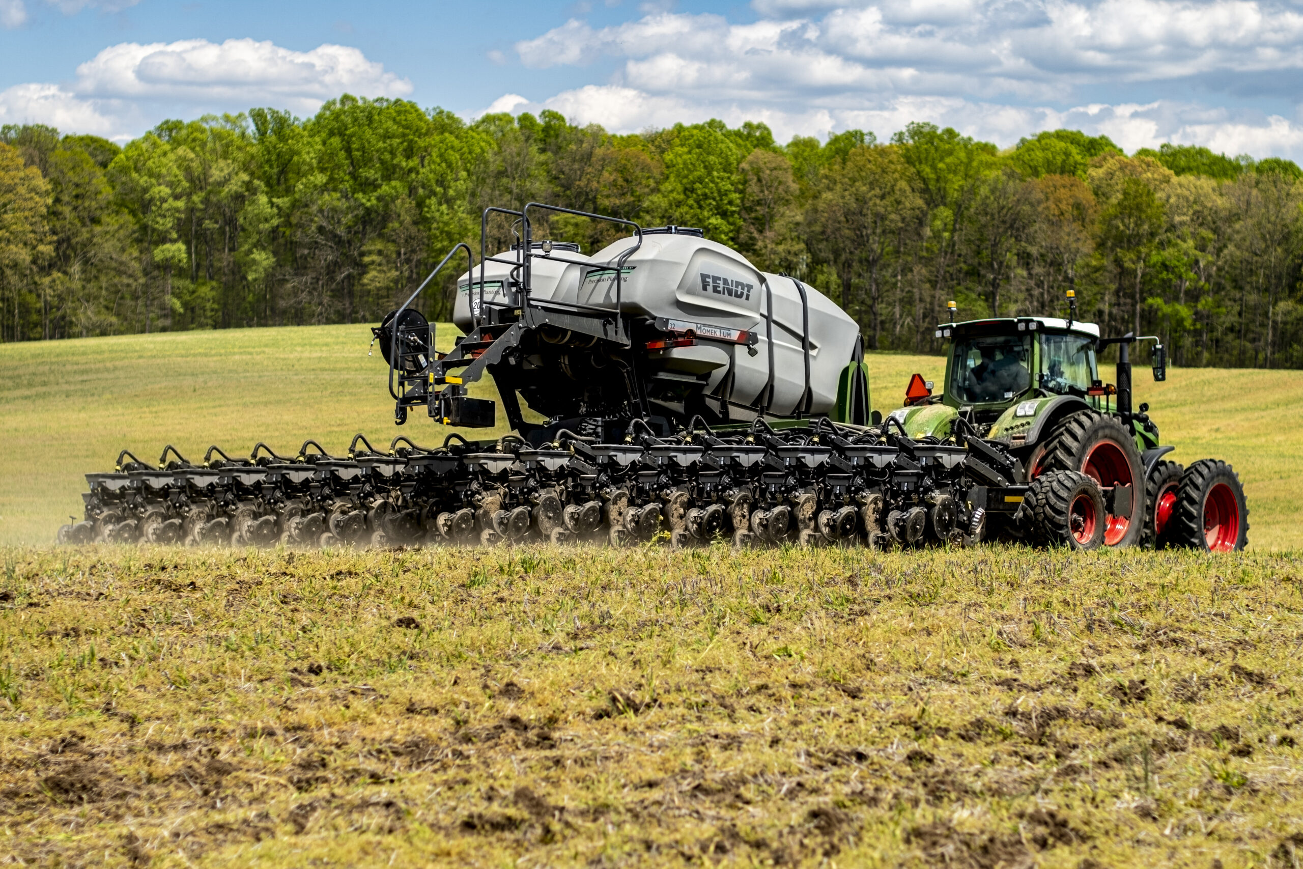 Fendt Momentum planter being pulled by a tractor through a field.