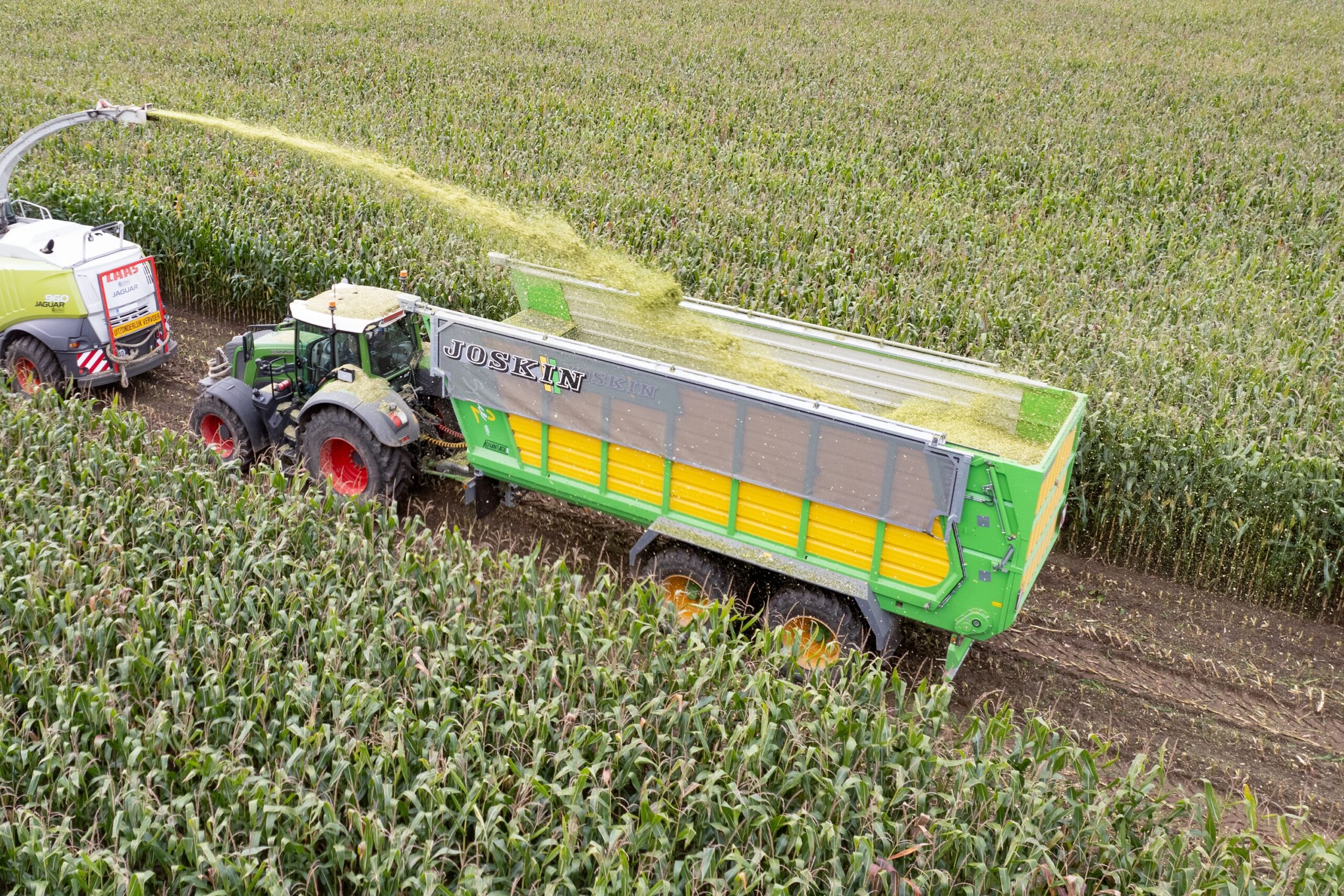 Joskin silage trailer pulled by a tractor through a field